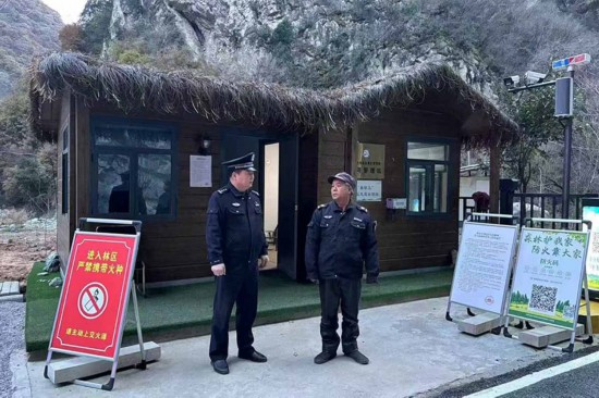 溫軍文（左）在和秦嶺聯(lián)防的民間工作人員交談。李凱攝